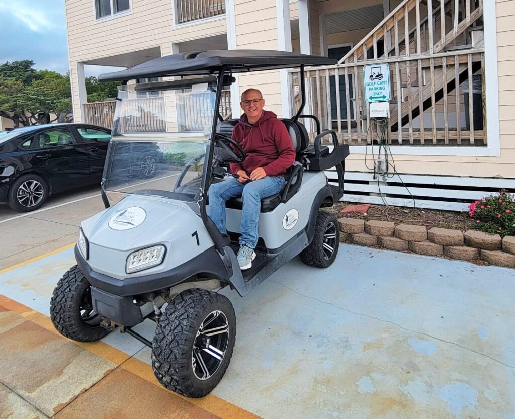 Person seated in a parked golf cart.