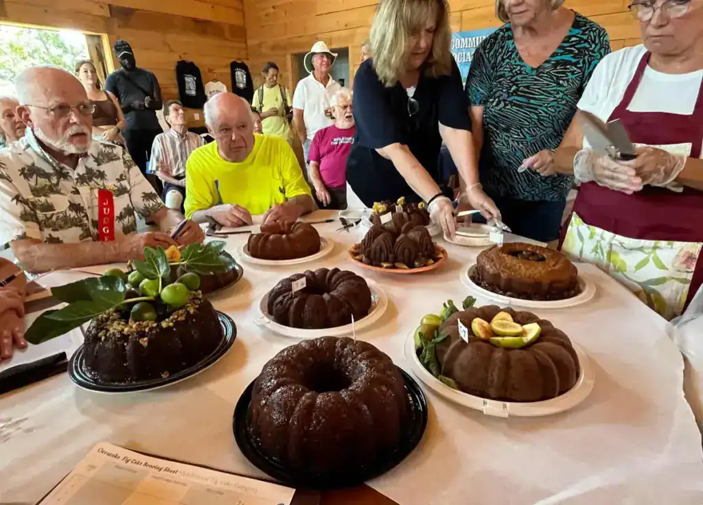 Judges evaluating diverse cakes at a competition.
