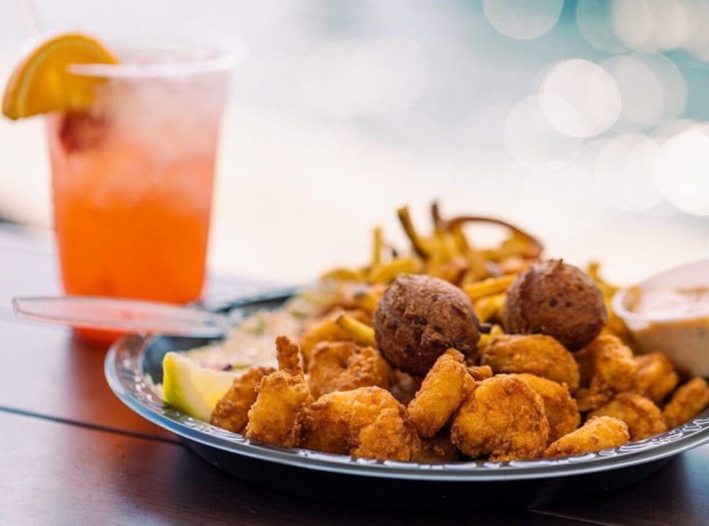 Fried seafood platter with drink on table.