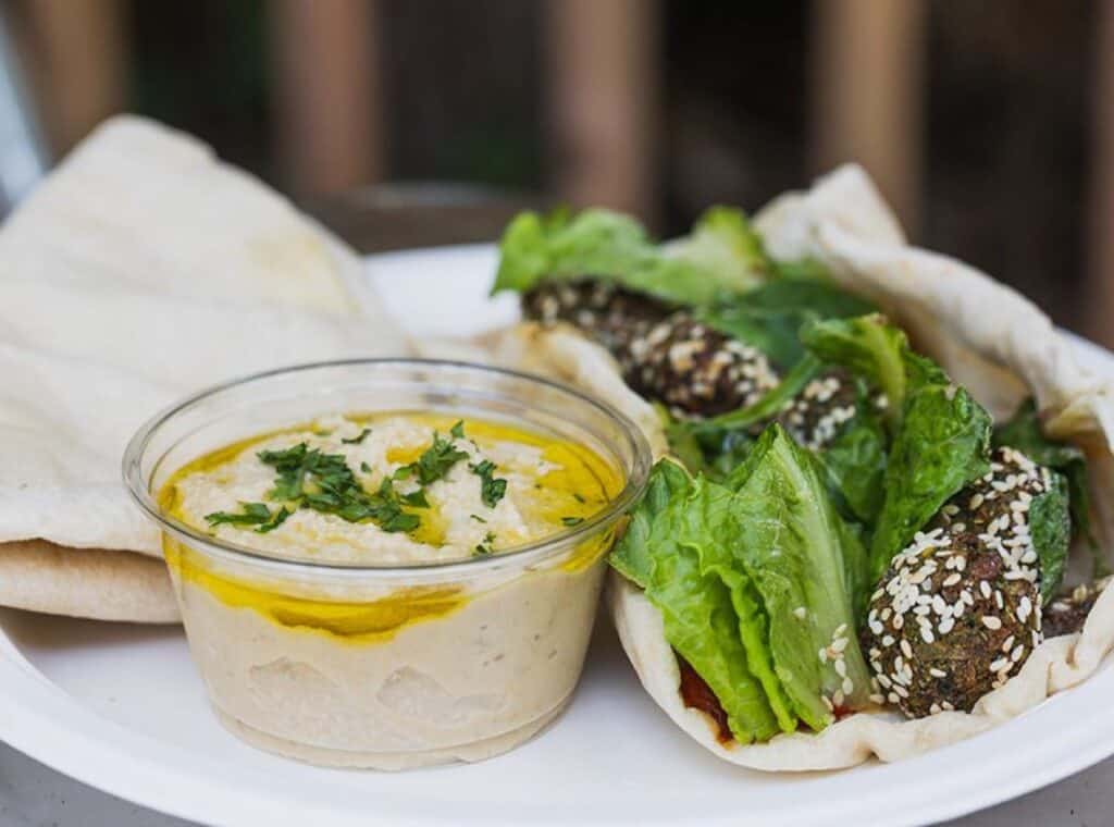 Falafel wrap with hummus and lettuce on plate.