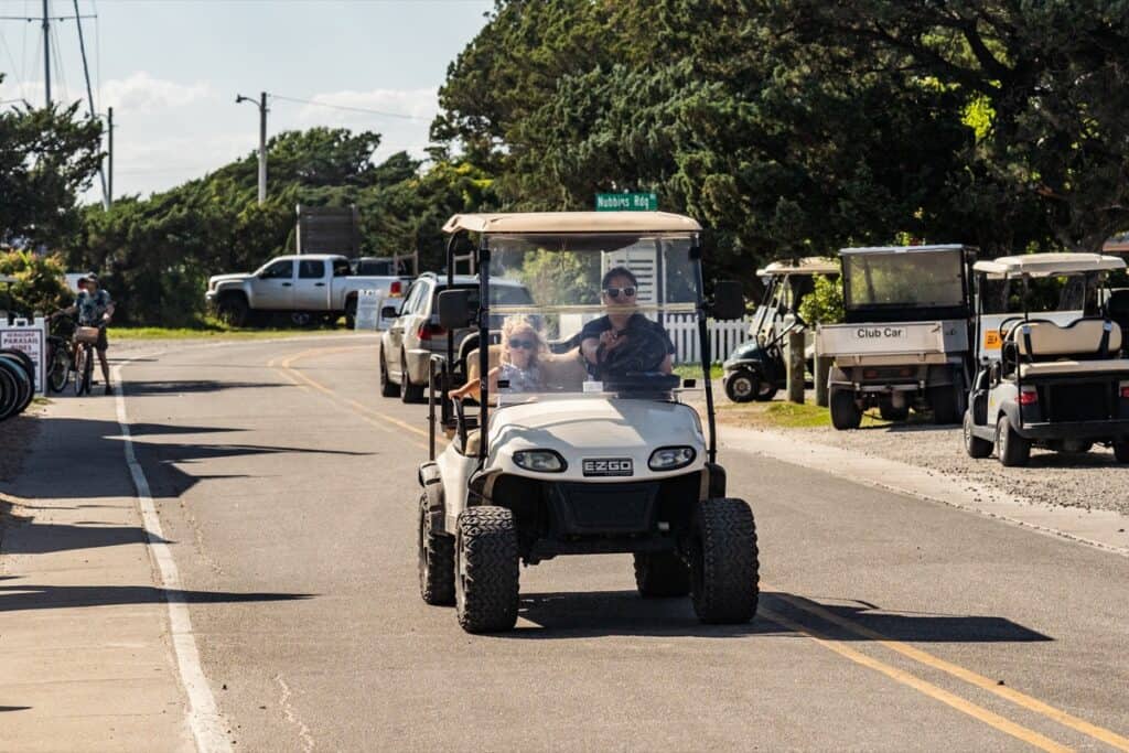 Golf cart driving on a sunlit street