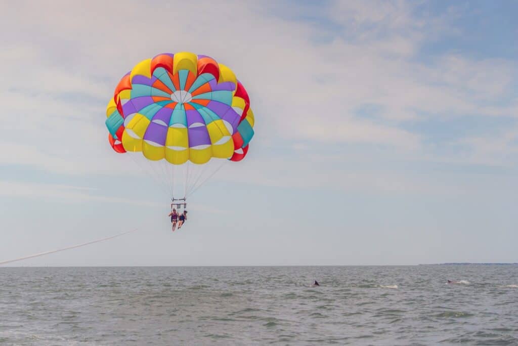 Parasailing over ocean with colorful parachute