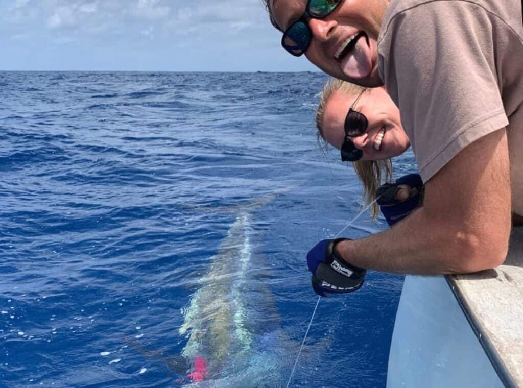 Smiling people fishing in the ocean.